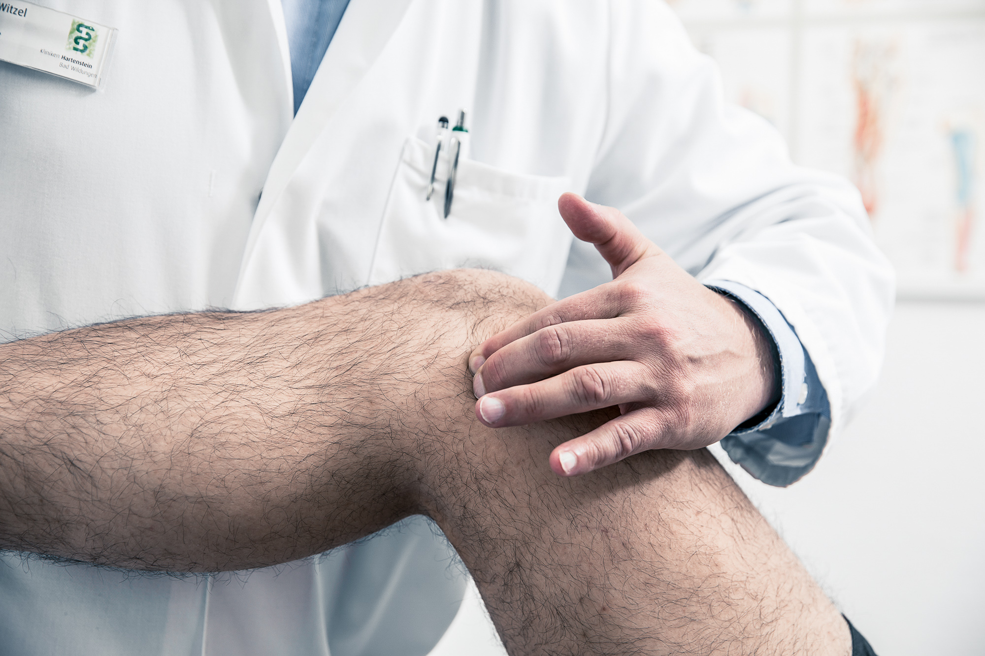 Arzt behandelt Knie eines Patienten